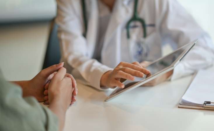 doctor with tablet talking to patient