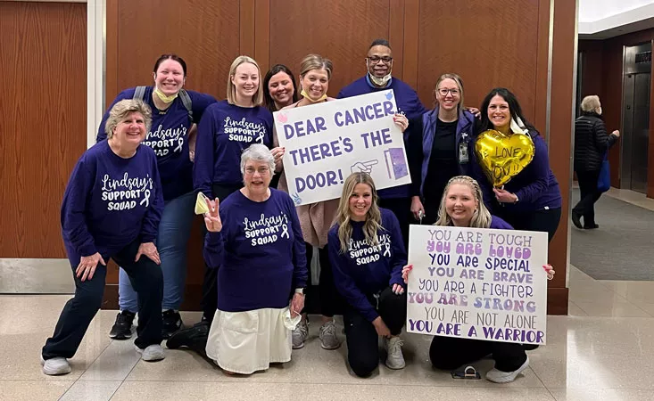 A group of people holding encouraging signs about beating pancreatic cancer.